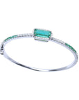 14K white gold bangle bracelet with a large emerald-cut Colombian emerald and natural diamond accents.