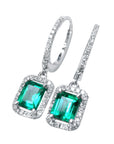 Pair of Colombian dangle emerald hoop earrings, plain top view on a left side position.