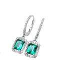 14k white gold hoop dangle earrings with medium deep green emeralds framed by diamonds.
