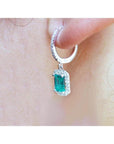 14k white gold hoop earrings with medium deep green emerald dangle, framed by natural diamonds.