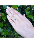 1.48 ct. cushion-cut Colombian emerald horseshoe ring in 14K yellow gold with diamonds on a hand.