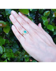 1.48 ct. cushion-cut Colombian emerald horseshoe ring in 14K yellow gold with diamonds on a hand.