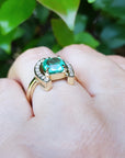 The underside view of a horseshoe emerald ring for women crafted in 14k yellow gold on a person's finger.