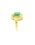 14K yellow gold horseshoe ring with a cushion-cut emerald and diamond accents.