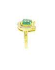 14K yellow gold horseshoe ring with a cushion-cut emerald and diamond accents.