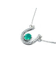 14K white gold horseshoe necklace with oval emerald and natural diamonds.