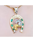 18K yellow gold horseshoe pendant with emeralds, diamonds, and a silver horse head.