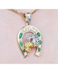 18K yellow gold horseshoe pendant with emeralds, diamonds, and a silver horse head.