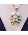18K yellow gold horseshoe pendant with emeralds, a silver horse head, and gold horse head on a chain.