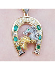 18K yellow gold horseshoe pendant with emeralds, diamonds, and a silver horse head.