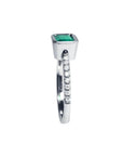 14K white gold ring with a bezel-set emerald and prong-set accent diamonds on the band.