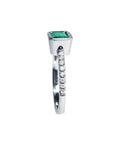 14K white gold ring with a bezel-set emerald and prong-set accent diamonds on the band.
