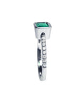 14K white gold ring with a bezel-set emerald and prong-set accent diamonds on the band.