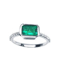 This inexpensive natural emerald ring displays the bezel set emerald and accent diamonds on the band.