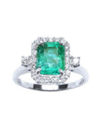 This inexpensive emerald engagement ring with a halo diamond is made of 14k white gold.