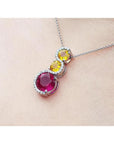 14K white gold ruby journey pendant with two yellow sapphires and diamond accents.