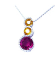14K white gold journey pendant with a round ruby, two yellow sapphires, and diamond accents.