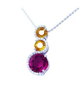 14K white gold journey pendant with a round ruby, two yellow sapphires, and diamond accents.