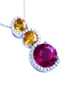 14K white gold ruby journey pendant with two yellow sapphires and diamond accents.