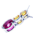 14K white gold ruby journey pendant with oval ruby, two yellow sapphires, and diamond accents.