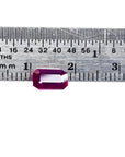 1.12 ct deep red emerald-cut natural ruby gemstone next to a ruler for scale.