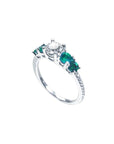 14K white gold ring with a round diamond center and four side emeralds.