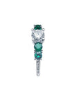 14K white gold ring with a round diamond center and four round green emeralds.