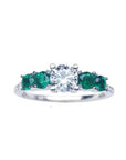 A women's round cut natural diamond ring with side colombian emeralds crafted in 14k white gold.