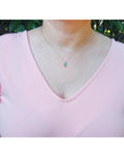 Ladies' 14K gold necklace with emerald-cut Colombian emerald slider pendant and halo diamonds.