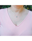 Ladies' 14K gold necklace with emerald-cut Colombian emerald slider pendant and halo diamonds.