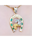 18K yellow gold horseshoe pendant with emeralds, diamonds, and horse head design.