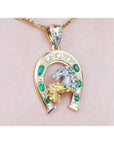 18K yellow gold horseshoe pendant with emeralds, diamonds, and horse head design.