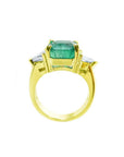 18k yellow gold ring with a GIA 4.16 ct emerald and two trillion side diamonds.