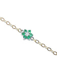 14K yellow gold chain bracelet with a central flower-shaped cluster of six green emeralds and one diamond.