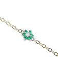 14K yellow gold chain bracelet with a central flower-shaped cluster of six green emeralds and one diamond.