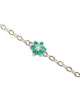 14K yellow gold chain bracelet with a central flower-shaped cluster of six green emeralds and one diamond.