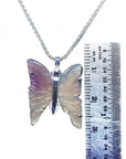 Lavender agate butterfly pendant with sterling silver setting on a chain, next to a ruler for scale.