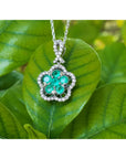 Emerald cluster necklace with round cut emeralds and diamonds in 14K white gold, clover-like design.