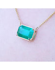 Emerald-cut Colombian emerald solitaire necklace in 18K yellow gold.
