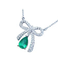 18K white gold bow-tie necklace with a pear-shaped deep green emerald.