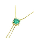 14K gold lariat necklace with a square emerald-cut natural Muzo emerald, milgrain, and prongs.