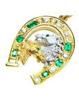 18K yellow gold horseshoe pendant with emeralds, diamonds, and two horse heads.
