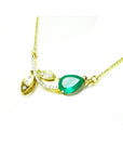 1.66 carat pear-cut natural emerald necklace in 14K yellow gold with diamond accents and leaf design.