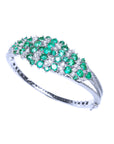 A white gold emerald bangle bracelet with natural diamonds on top and partial side profile view.