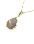 Pear-shaped Ethiopian Welo opal pendant with fiery red-orange play of color, set in 14K yellow gold.