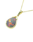 Pear-shaped Ethiopian Welo opal pendant with fiery red-orange play of color, set in 14K yellow gold.