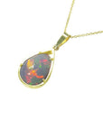 Pear-shaped Ethiopian Welo opal pendant with fiery red-orange play of color, set in 14K yellow gold.