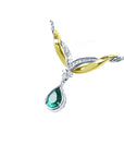left side angle of a pear cut solitaire emerald dangling from a necklace made in 14k white and yellow gold