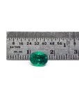 GIA Certified F1 0.98 ct. Oval Muzo Colombian Emerald loose emerald next to a ruler for measure.