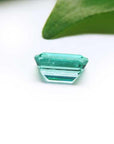 1.83 carat emerald-cut Colombian emerald with a vibrant bluish-green hue on a white background.